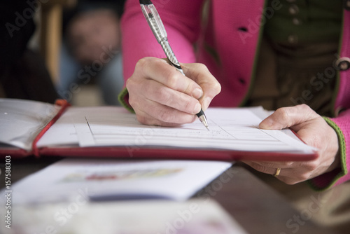 Frau unterschreibt mit Kugelschreiber