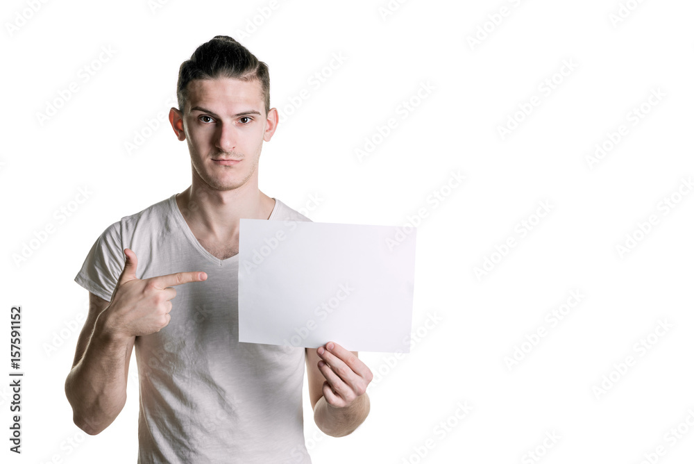 Young handsome guy with a blank sheet of paper looking into the frame. Place for signature, text. Horizontal frame Young handsome guy with a blank sheet of paper looking into the frame. Place for signature, text. Horizontal frame