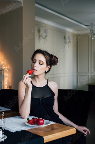 Young pretty woman eating Breakfast strawberries