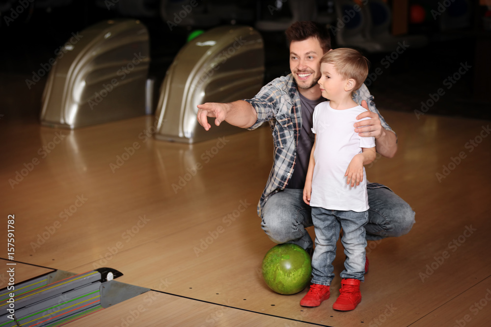 Naklejka premium Cute child with father in bowling club