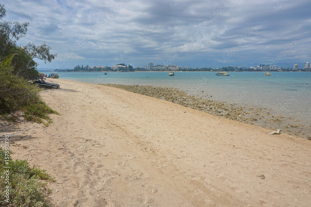 Beach shore of the islet Canard and coastline of the Anse Vata and the city of Noumea in background, southwest coast of Grande Terre island, New Caledonia, south Pacific ocean, Oceania