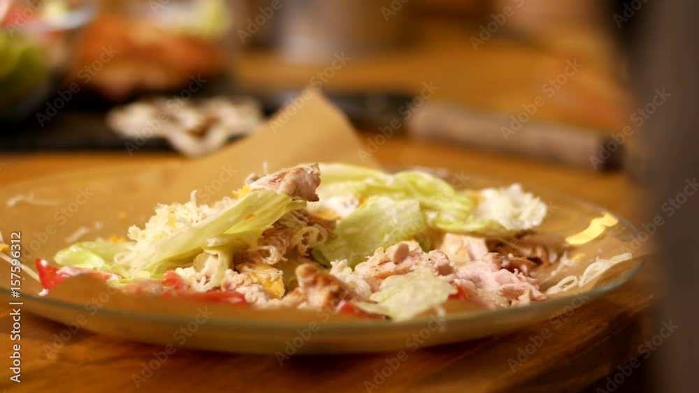 Man touches caesar salad by the fork Man touches caesar salad by the fork