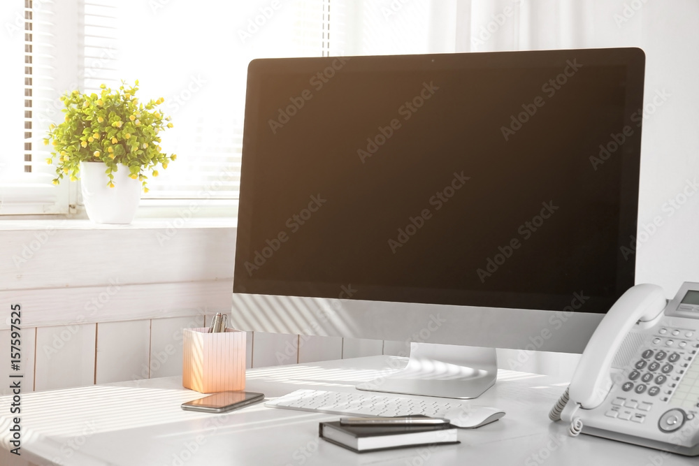 Obraz premium Modern comfortable workplace with computer and window blinds