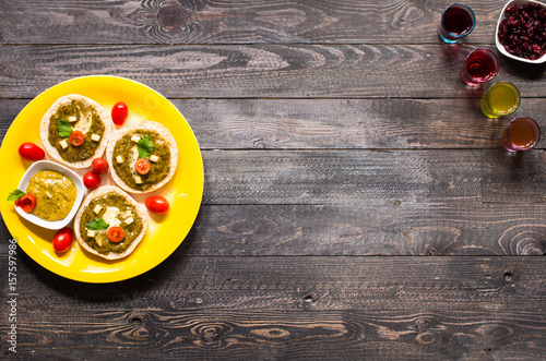 tasty and delicious bruschetta with avocado, tomatoes, cheese, herbs, chips and liquor, on a wooden background.