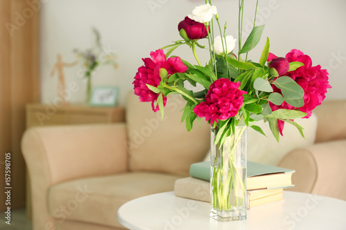 Beautiful peonies and eustoma flowers in vase on light table