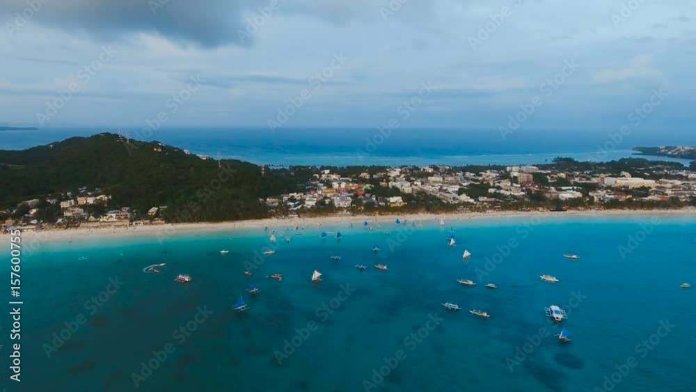 Aerial view: Sunset over the sea in the background boats,sailing boat, orange sky and islands.Tropical beach at sunset. Sailing boats at sunset in the sea. White sand beach. Travel concept. Beautiful Aerial view: Sunset over the sea in the background boats,sailing boat, orange sky and islands.Tropical beach at sunset. Sailing boats at sunset in the sea. White sand beach. Travel concept. Beautiful