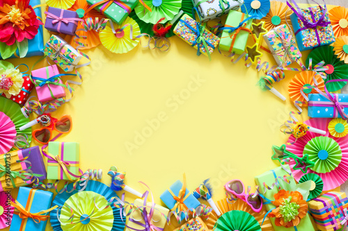Gifts, garland, festive decor and confetti. Yellow background.