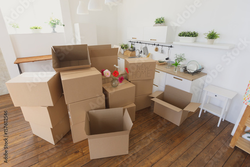 unpacking boxes in new home and putting things away in kitchen, big cardboard boxes in new home. Moving to a new apartment concept