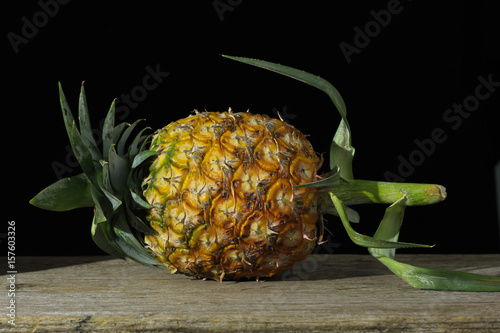 Pineapple on a wooden backdrop in black