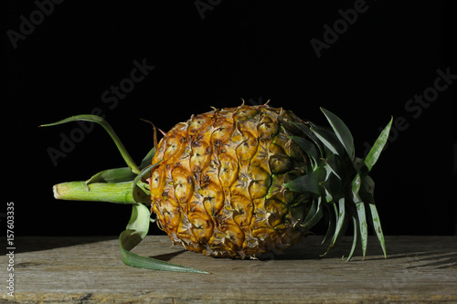 Pineapple on a wooden backdrop in black