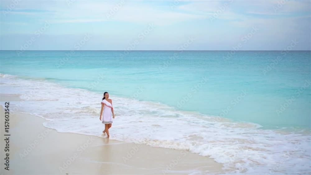 Beautiful young woman at beach walking in shallow water. Beautiful young woman at beach walking in shallow water.