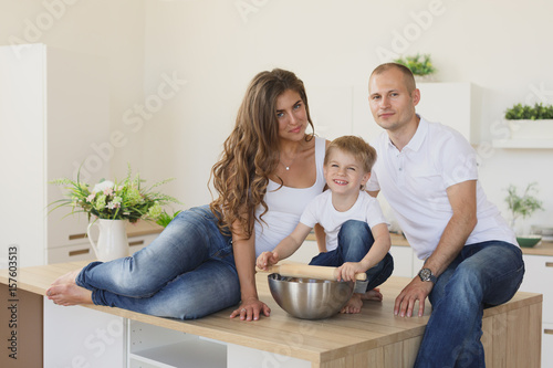 Happy family looking at the camera in kitchen photo