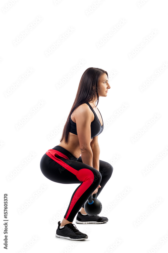 A young woman in sportswear makes deadlift with a weight in full plait position on a white isolated background. Side view A young woman in sportswear makes deadlift with a weight in full plait position on a white isolated background. Side view