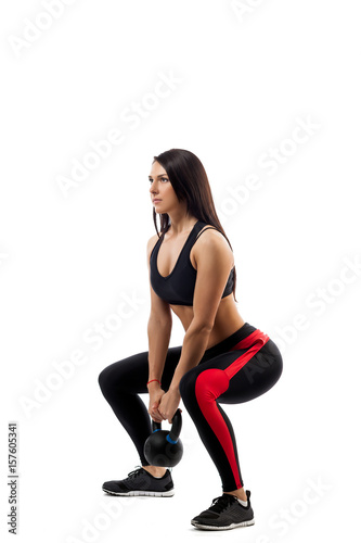 Exercise of deadlift with weight. Young woman in sportswear makes do-it-yourself pull with weight in sitting position, side view, on white isolated background