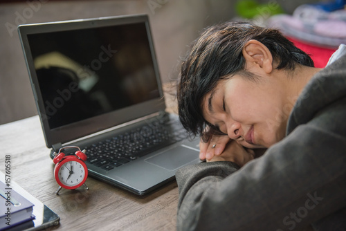 Young tired businesswoman sleeping at office desk.