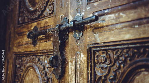 Antique wooden carved door and metal bolt.