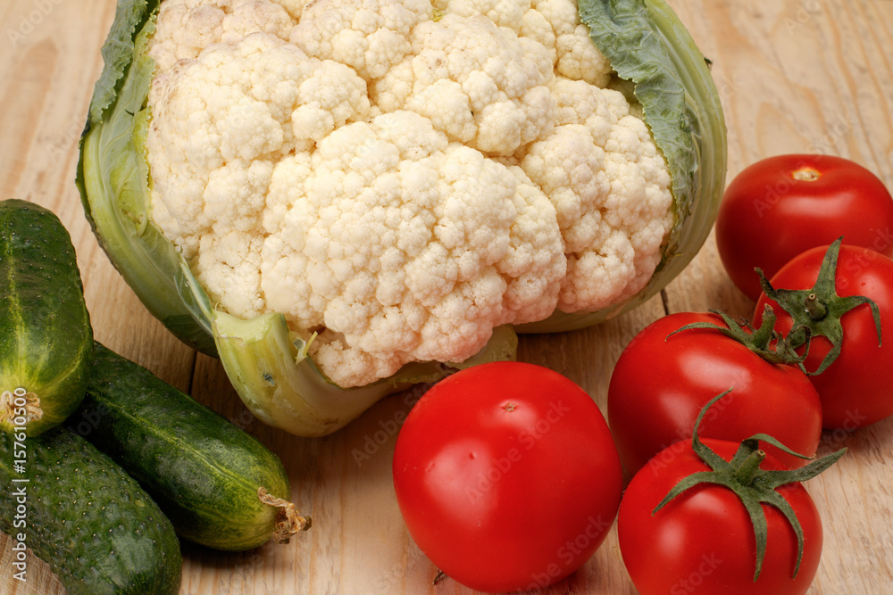 Cucumber tomatoes cauliflower on white wooden background Cucumber tomatoes cauliflower on white wooden background