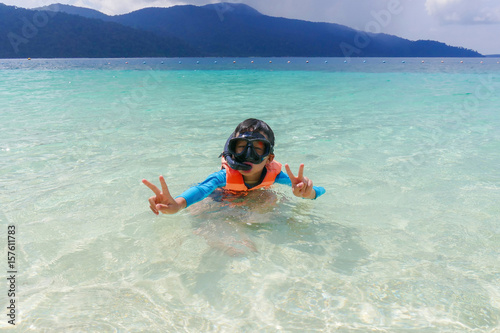 Young asian boy snorkeling with mask and snorkel in the sea water