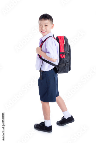 Happy asian schoolboy walking over white background