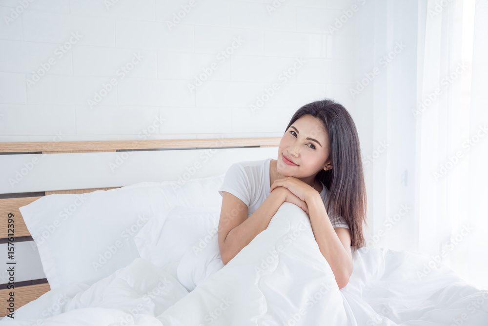 Beautiful asian woman sitting on bed in bedroom Beautiful asian woman sitting on bed in bedroom