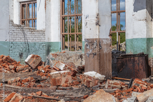 The fragments of red brick and plaster of the ruined house