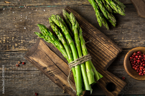 banches of fresh green asparagus on wooden background photo