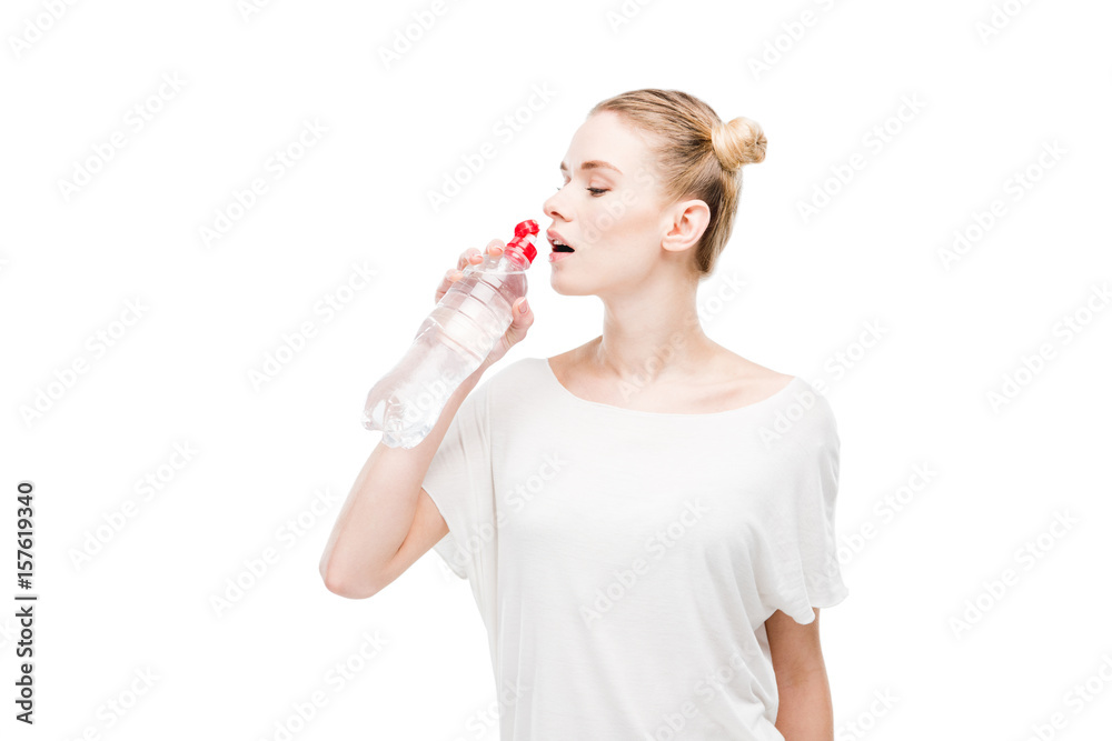 Attractive young woman in white t-shirt drinking water from bottle isolated on white Attractive young woman in white t-shirt drinking water from bottle isolated on white