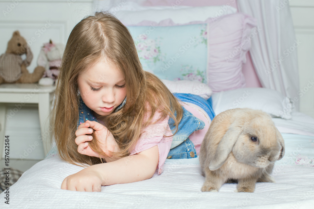 girl with pet rabbit lying on the bed. the concept of Allergy girl with pet rabbit lying on the bed. the concept of Allergy