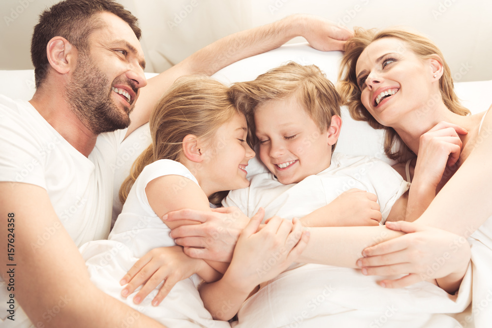 happy smiling caucasian family lying in bed in the morning happy smiling caucasian family lying in bed in the morning