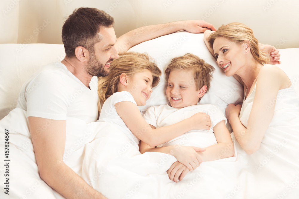 happy smiling caucasian family lying in bed in the morning