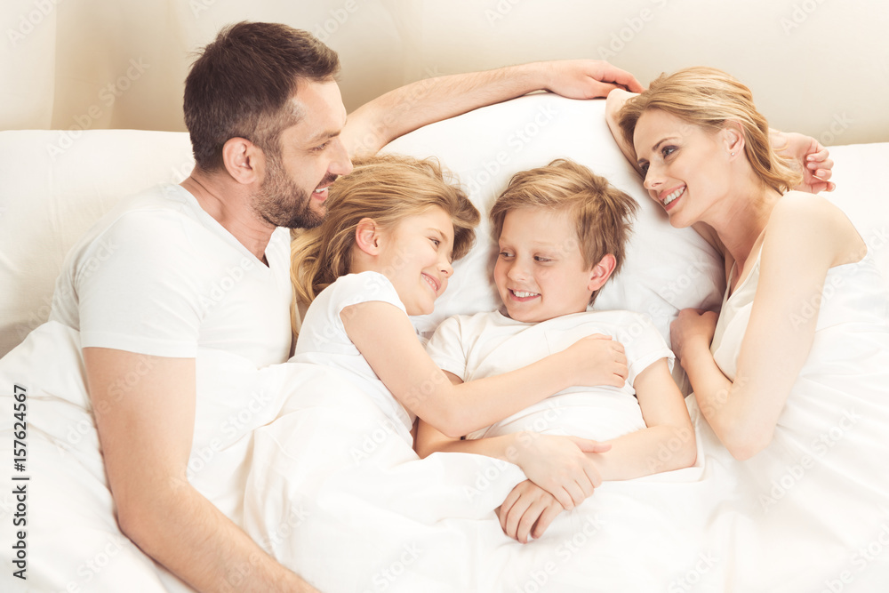 happy smiling caucasian family lying in bed in the morning happy smiling caucasian family lying in bed in the morning
