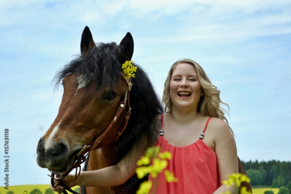 Fototapeta premium mit dem pferd im rapsfeld