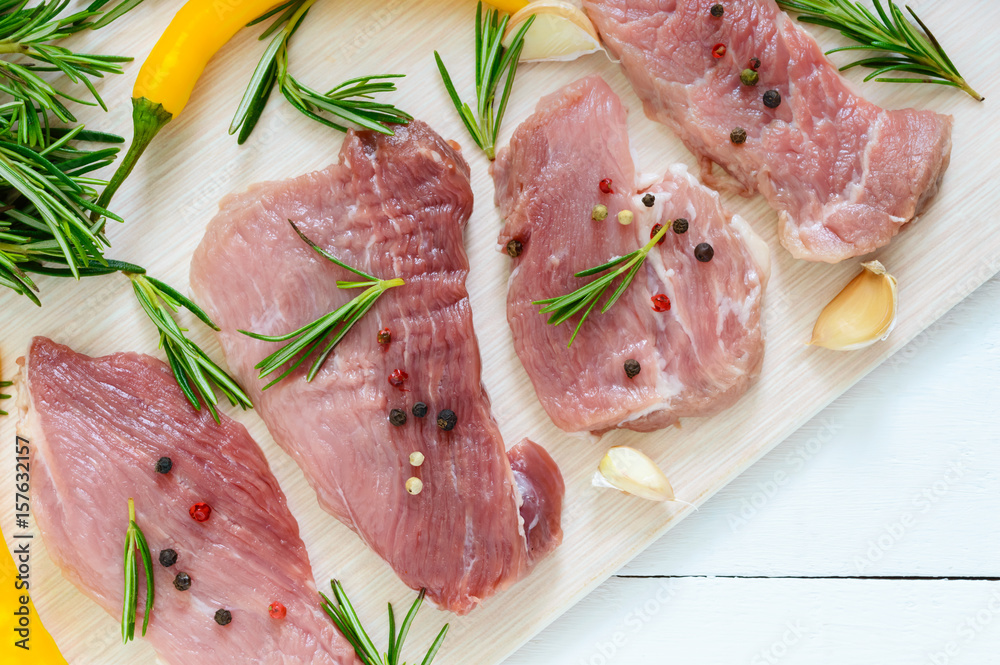 Raw flat meat for steak (chop) with spices on a light background. Raw flat meat for steak (chop) with spices on a light background.