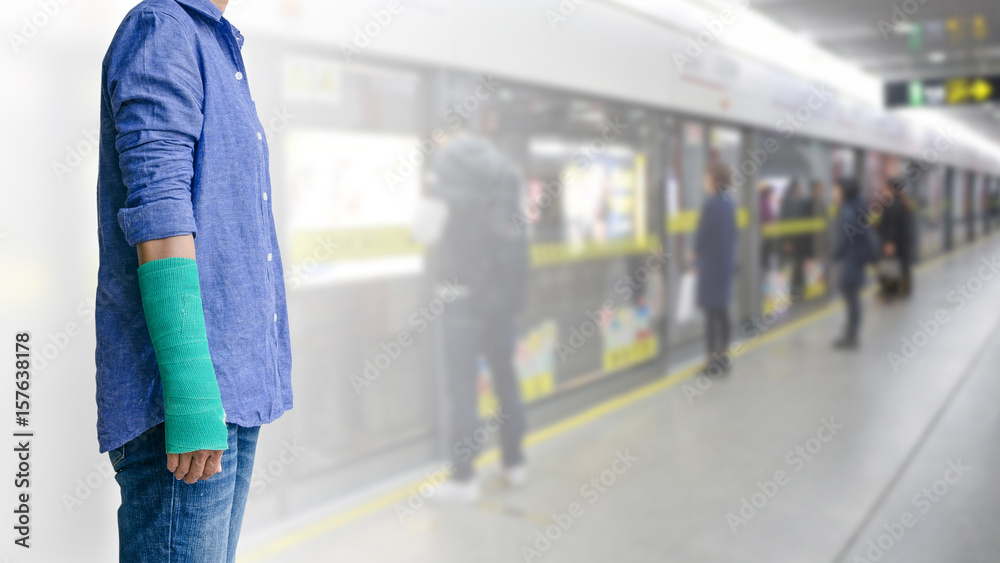 Naklejka premium Injured woman with green cast on hand and arm on motion blur in the subway station background, travel insurance concept