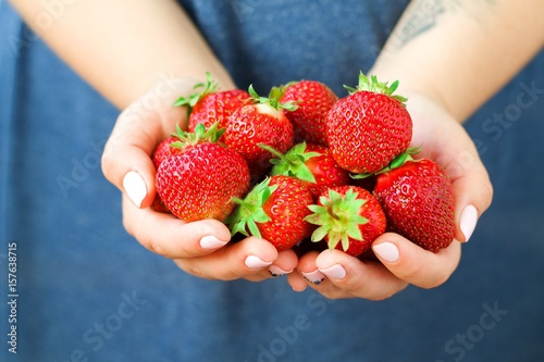 Women's hands hold fresh juicy strawberries