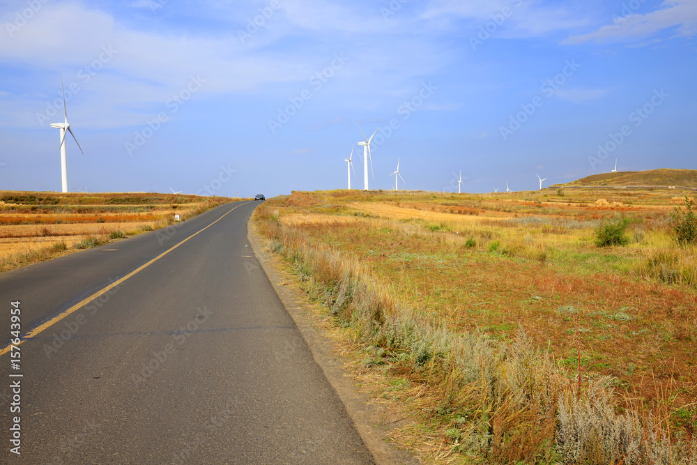Asphalt road and wind turbines