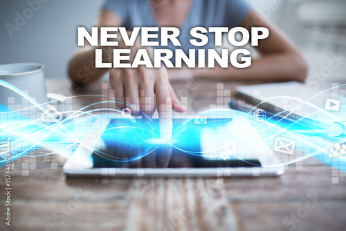 Foto Woman using tablet pc, pressing on virtual screen and selecting never stop learning