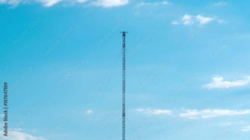 High telecommunication radio tower broadcast antenna on blue sky with clouds timelapse High telecommunication radio tower broadcast antenna on blue sky with clouds timelapse