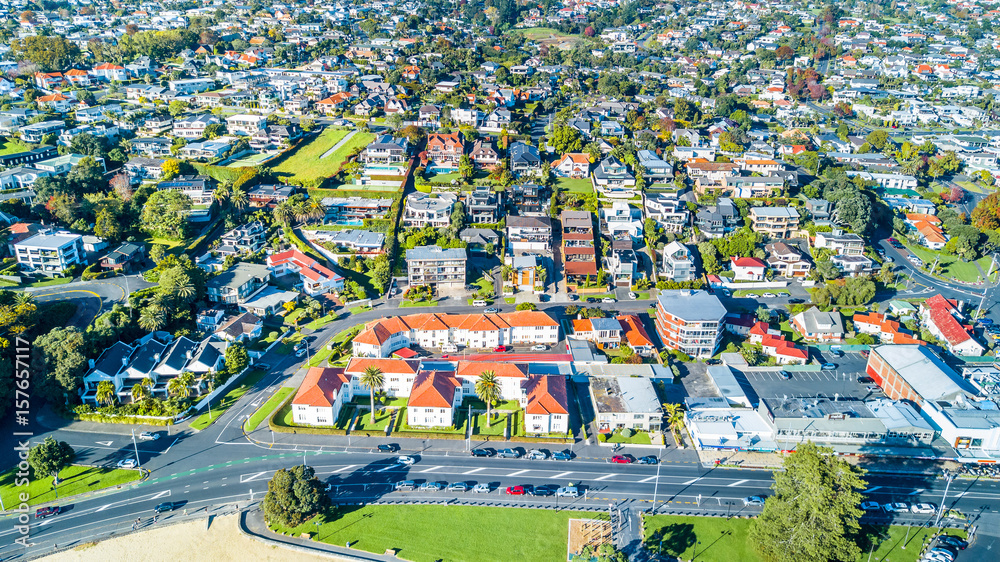 Aerial view on residential suburbs with cars parked along the road on the foreground. Auckland, New Zealand.