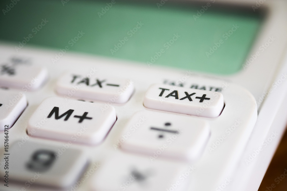 Close up of tax button on business white calculator Close up of tax button on business white calculator