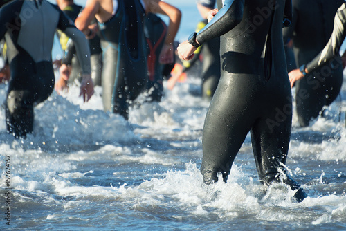Triathletes running out of the water on triathlon race