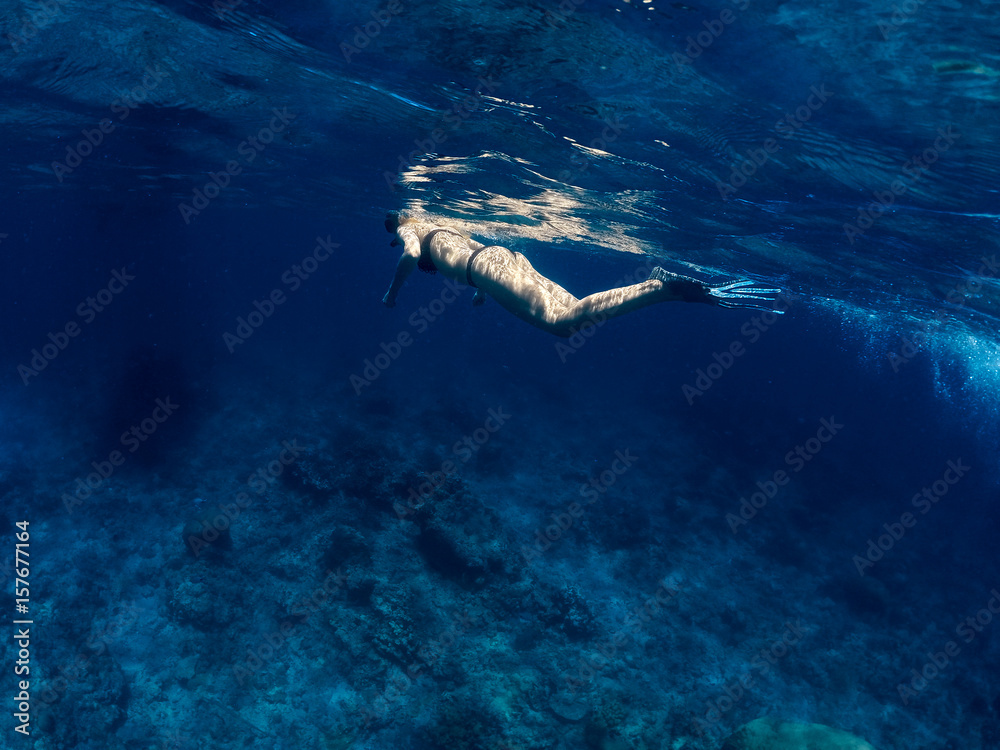 Underwater swimming. Female snorkeling in ocean.