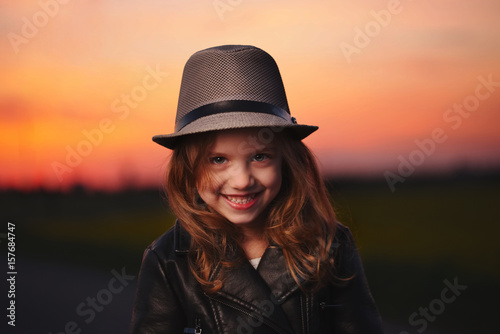 little girl with hat on evening sunset