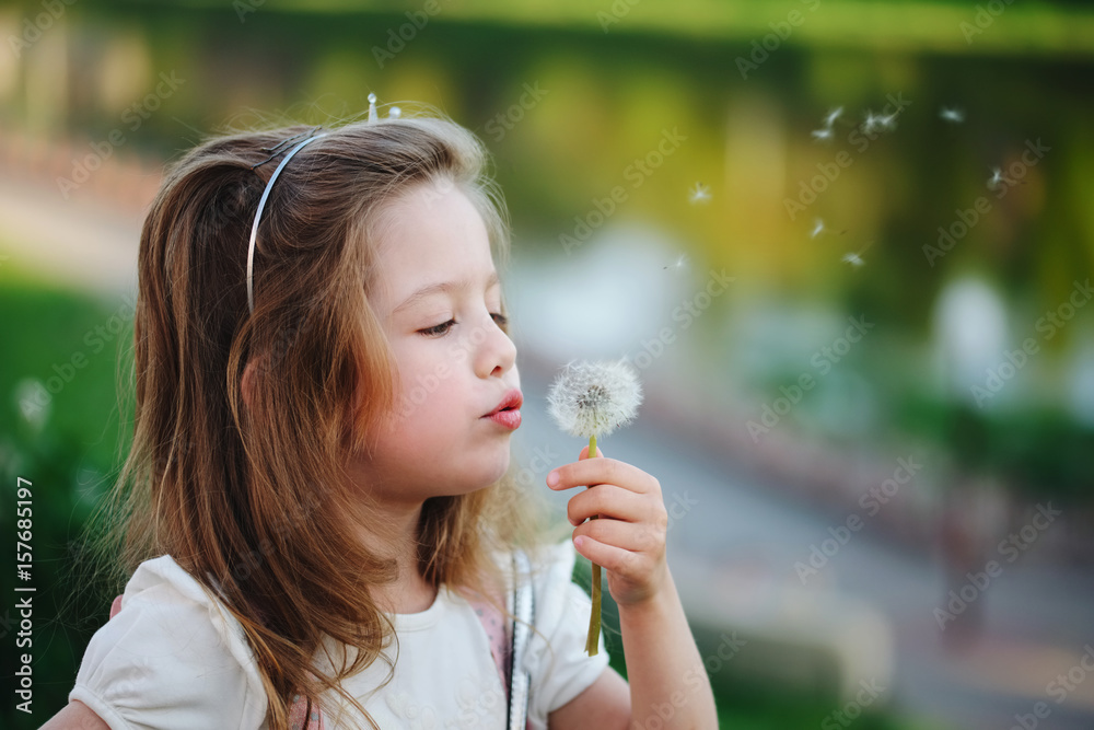 little girl with dandelion in park