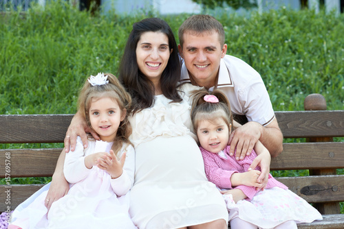 happy family in summer city park outdoor, pregnant woman, parent and children, bright sunny day and green grass, beautiful people portrait © soleg
