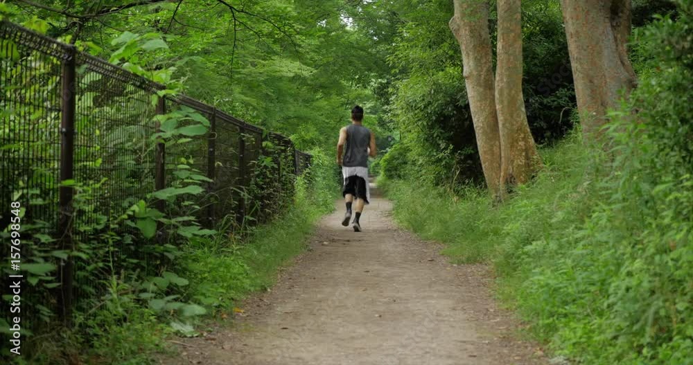 Japanese man runs down a beautiful geen path Japanese man runs down a beautiful geen path