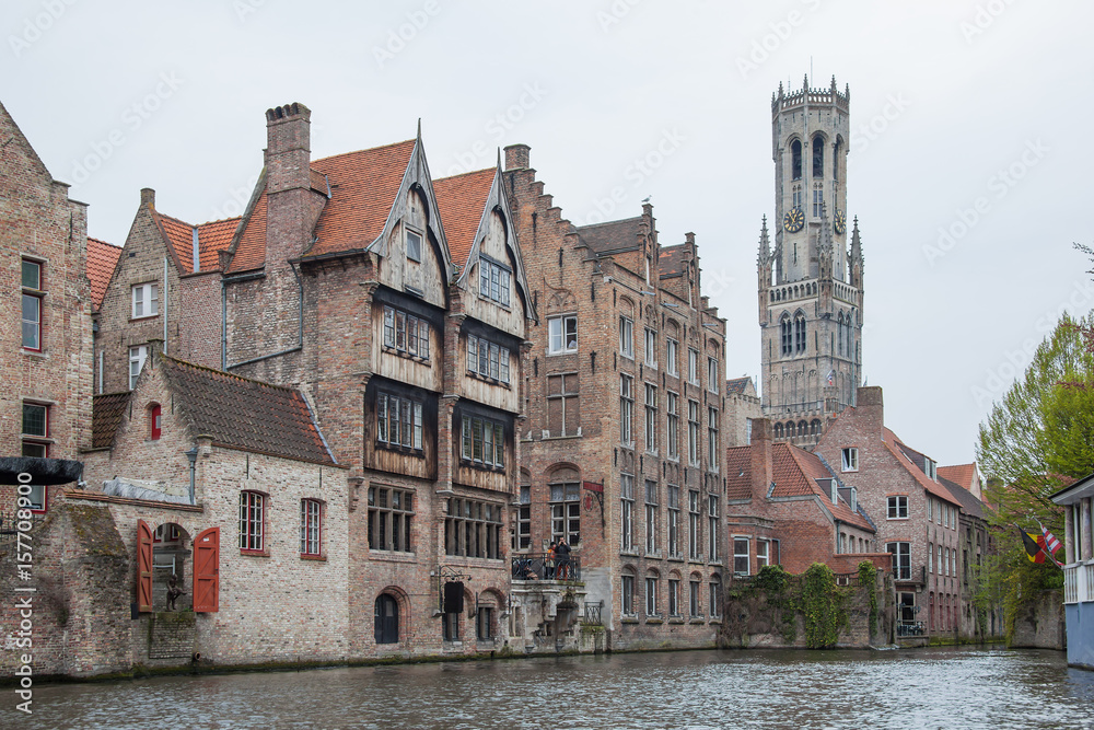 Fototapeta premium Old town of Bruges (Brugge) with brick houses above canal and famous Belfry on the background, Belgium