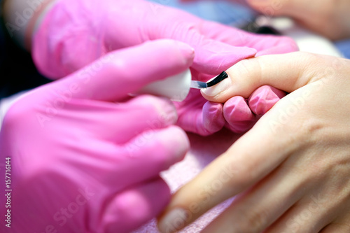 Manicurist painting nails with nail polish