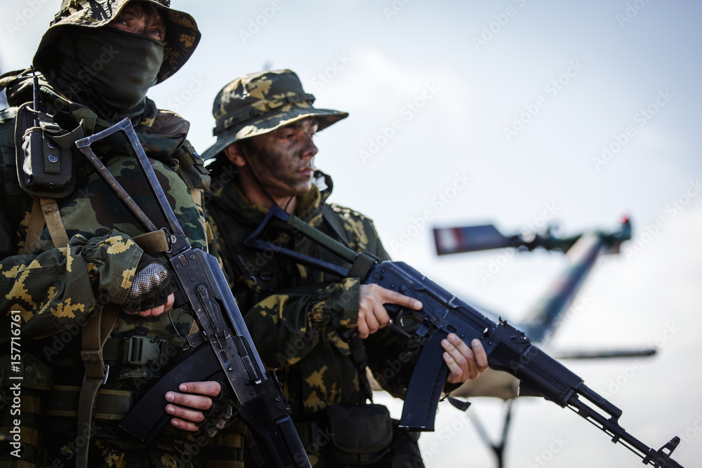 Photos of a group of military men with a gun in front of a helicopter Photos of a group of military men with a gun in front of a helicopter