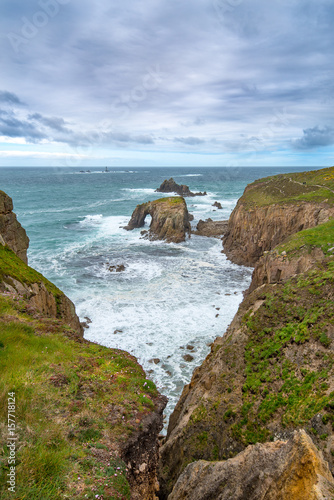 Enys Dodman, a rock arch about 1km south of Lands End, The Armed Knight and the Longships Reef can be seen beyond. photo